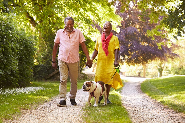 laughing senior couple walking their dog on a walking path retirement strategies martinez georgia